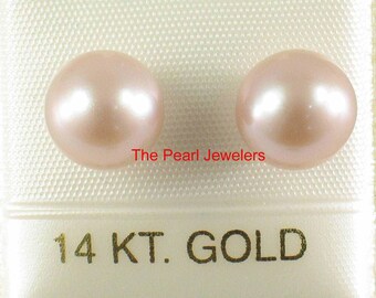May include: Two blush-colored pearls, presented in a white package. The pearls have a lustrous sheen. The text "The Pearl Jewelers" and "14 KT. GOLD" are visible.