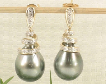 Könnte beinhalten: Ein Paar elegante Ohrhänger. Jeder Ohrring hat eine große, birnenförmige, dunkelgraue Perle, die an einer goldfarbenen Fassung hängt. Die Fassung hat ein Spiraldesign und ist mit kleinen, funkelnden Steinen besetzt.
