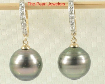Könnte beinhalten: Ein Paar Ohrhänger mit großen, dunkelgrauen Perlen. Die Ohrringe haben goldfarbene Reifen mit einer Reihe kleiner, klarer Steine. Der Text "The Pearl Jewelers" ist sichtbar.