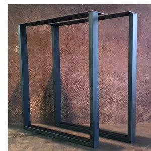 May include: Two black metal table legs with a square frame design. The legs are made of sturdy metal and have a matte black finish.