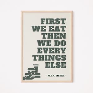 以下が含まれることがあります： ベージュの額縁に入ったプリントで、緑色の引用文が書かれています。「First we eat then we do every things else - M.F.K. Fisher -」