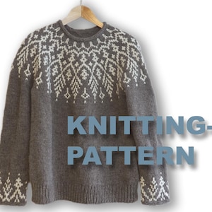 Könnte beinhalten: Ein grauer Strickpullover mit einem weißen Schneeflockenmuster am Hals und an den Ärmeln. Der Pullover hängt an einem Holzbügel. "KNITTING-PATTERN" steht in blauer Schrift unter dem Pullover.