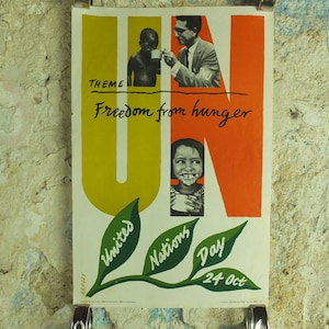 May include: Vintage poster with the text "Freedom from hunger" and "United Nations Day 24 Oct." The poster features illustrations of people and the letters "UN" in yellow and orange. Green leaves with text are at the bottom.