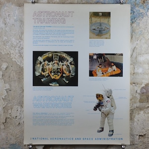 以下が含まれることがあります： 「Astronaut Training」と「Astronaut Wardrobe」のタイトルが付いた、ヴィンテージのNASAポスター。ポスターには、訓練中の宇宙飛行士と宇宙服を着た宇宙飛行士の画像が掲載されています。テキストには、アポロ宇宙服とアメリカ航空宇宙局の詳細が含まれています。