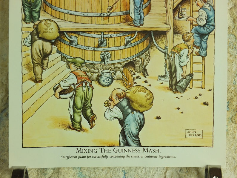 May include: Illustration of a brewery scene with workers carrying sacks of malt and other ingredients. The image shows a large wooden vat and the text "MIXING THE GUINNESS MASH."