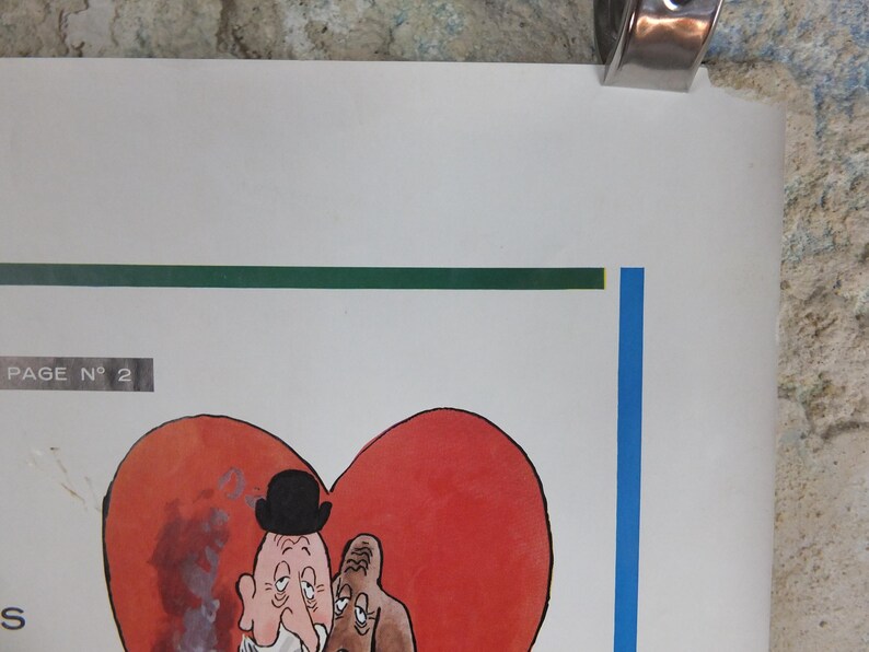May include: A vintage comic illustration of two cartoon figures within a red heart shape. One figure wears a bowler hat. The artwork is on a white background with a green and blue border. A metal clip holds the top of the paper.