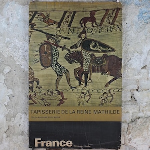 Może przedstawiać: Plakat w stylu vintage przedstawiający fragment arrasu z Bayeux, przedstawiający średniowieczne sceny bitewne z postaciami, końmi i tekstem. Plakat ma beżowe tło z czarnym i brązowym tekstem na dole oraz słowem "France".