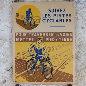 May include: Vintage French poster featuring cyclists and text in blue and black. The poster has a yellow and brown background with the text "SUIVEZ LES PISTES CYCLABLES" and "POUR TRAVERSER LES VOIES METTEZ PIED A TERRE".