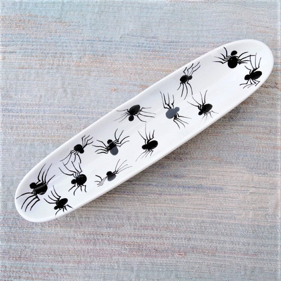 Spider trinket or pen tray with black spiders in white porcelain.
