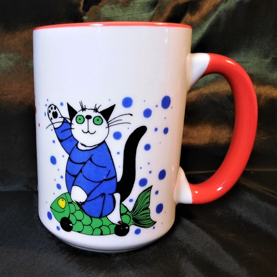 Three charming cats with a toy fish on a half pint mug with red handle