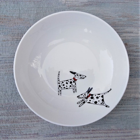Dalmatians playing on a cereal or dessert bowl.