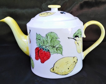 Teapot white bone china six cup hand decorated with fruit and with a yellow spout and handle.
