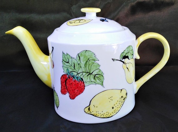 Teapot white bone china six cup hand decorated with fruit and with a yellow spout and handle.