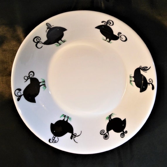 A dessert or soup bowl or dish of white bone china decorated with six black abstract chickens.