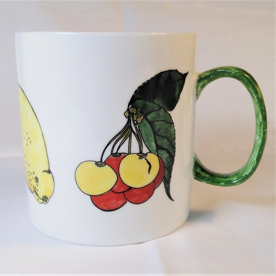 Fruiit decorated white china large mug with a green handle.
