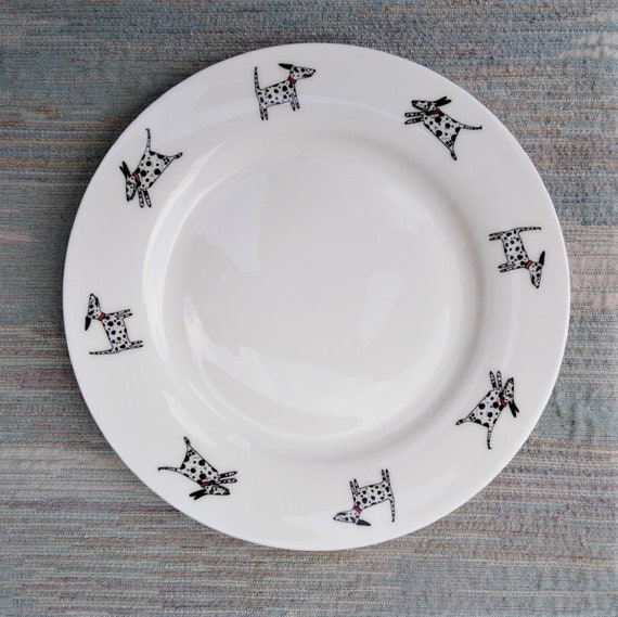 A side plate decorated with eight Dalmatians some running and some standing.
