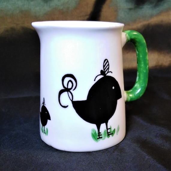 Milk jug in white fine bone china with black chicken and a green handle