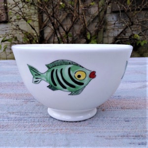 Bowl with green fish swimming around.