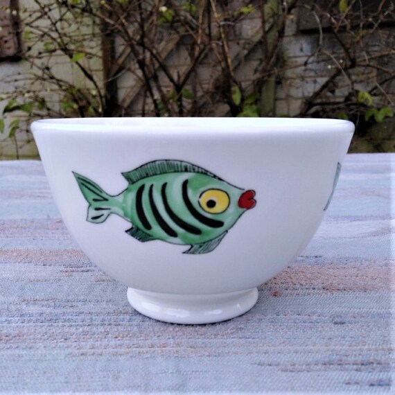 Bowl with green fish swimming around.