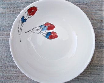 Red, white and blue feathers on a cereal dish.