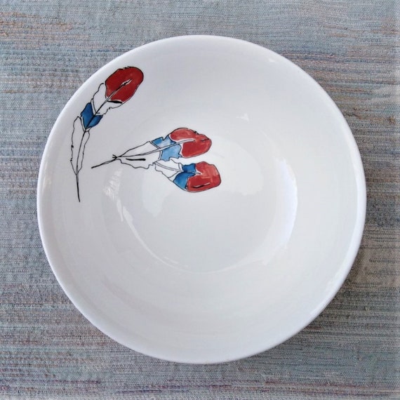 Red, white and blue feathers on a cereal dish.
