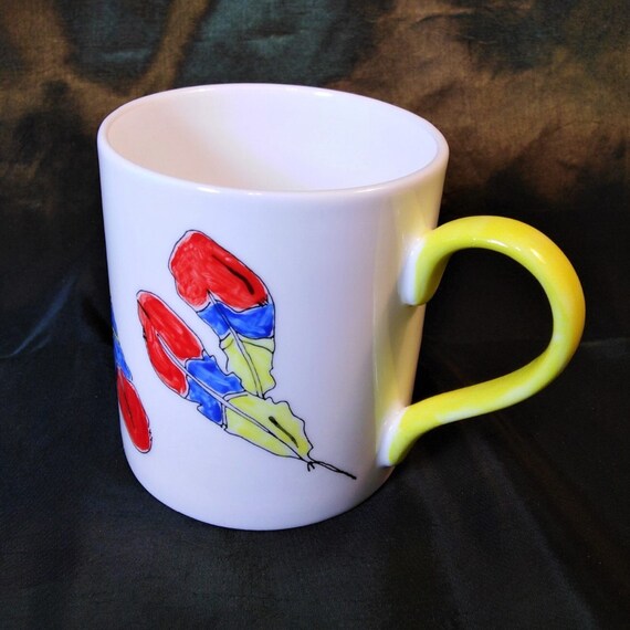 Coffee mug decorated with feathers.