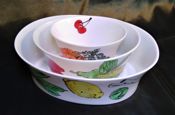 Fruit and Veg. A set of three pure white bone china oval bowls each hand decorated with different fruit and vegetables around the outside.