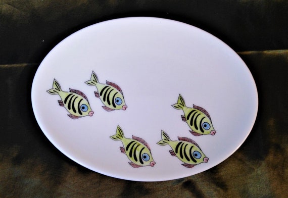 An oval shallow dish decorated with amusing green fish. Useful as a side dish or a large and useful trinket tray.