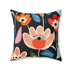 May include: A black throw pillow with a colorful floral pattern. The pillow features pink, orange, and blue flowers with green leaves.