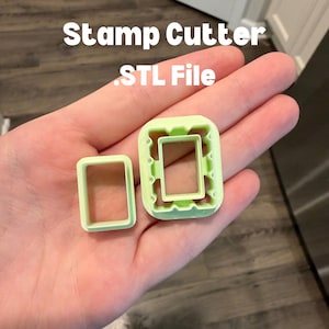 May include: Two light green rectangular stamp cutters, one larger and one smaller, are displayed. The larger cutter has a decorative outer edge. The text "Stamp Cutter .STL File" is above the cutters.