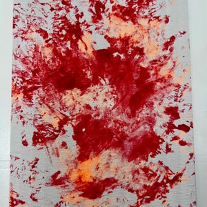 May include: Abstract painting on canvas with red and orange paint splatters on a white background.