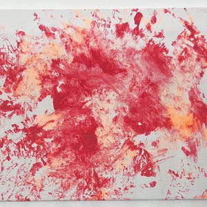 May include: Abstract painting with a red and orange splatter pattern on a white canvas.