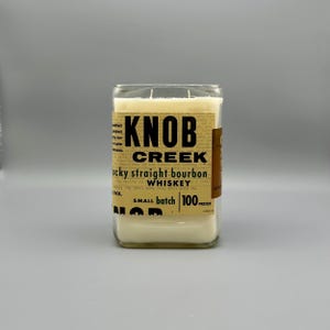 Puede incluir: Un tarro de vela de vidrio transparente con una etiqueta que dice "Knob Creek Kentucky Straight Bourbon Whiskey, Small Batch, 100 Proof".