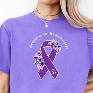 May include: Purple t-shirt with a purple ribbon and flowers, and the text "ulcerative colitis awareness" and "UC".