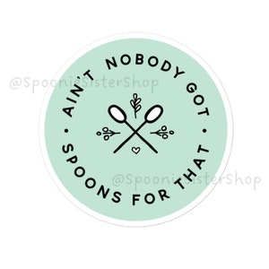 Puede incluir: Una pegatina redonda con fondo verde menta y borde blanco. La pegatina presenta una ilustración en blanco y negro de dos cucharas cruzadas con un pequeño corazón en el centro. El texto alrededor de las cucharas dice "Ain't Nobody Got Spoons For That."