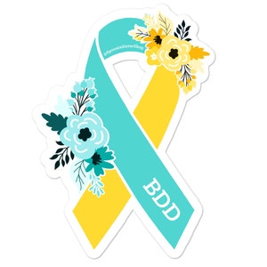 Pu&ograve; includere: Un nastro di consapevolezza turchese e giallo con accenti floreali e il testo "BDD".
