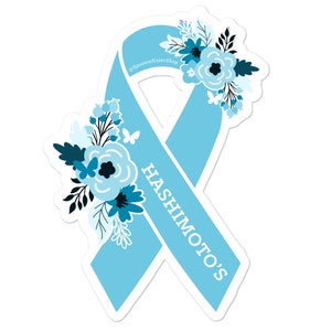 May include: Light blue ribbon with a floral design and the text "HASHIMOTO'S" on it. The ribbon is a symbol of awareness for Hashimoto's disease.