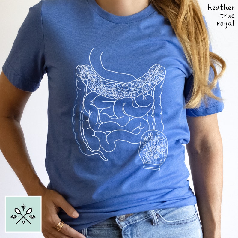 May include: A blue t-shirt with a white outline of the human digestive system with flowers inside. The text "heather true royal" is printed on the shirt.