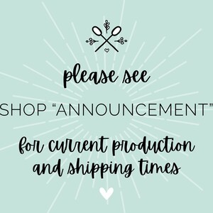 May include: A light blue background with a white starburst design. The text "please see SHOP "ANNOUNCEMENT" for current production and shipping times" is written in black cursive font. A small heart is at the bottom of the image.