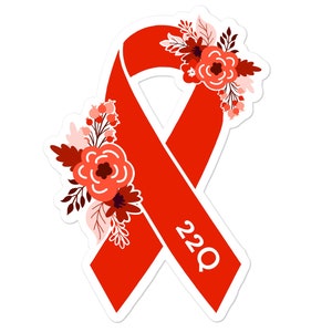 May include: Red awareness ribbon with floral accents and the text "22Q" in white.