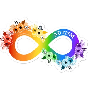Può includere: Simbolo di infinito arcobaleno con la parola "AUTISMO" in testo bianco. Il simbolo è decorato con fiori colorati.