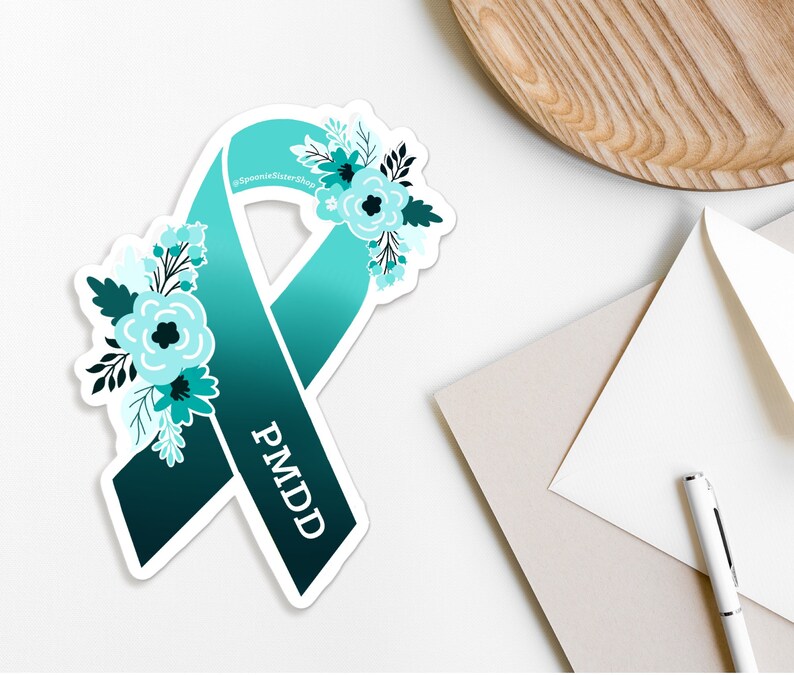 May include: Teal blue awareness ribbon with a floral design and the text "PMDD" on a white background.