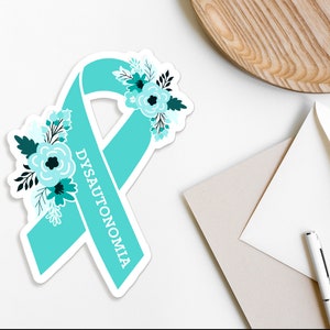 Op de afbeelding: Turquoise blauwe lint met een bloemenontwerp en het woord "DYSAUTONOMIA" erop.