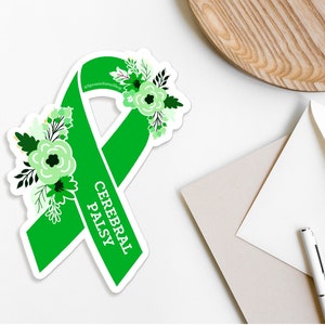 Pu&ograve; includere: Nastro verde con fiori bianchi e il testo "Cerebral Palsy" su uno sfondo bianco.