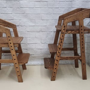 Könnte beinhalten: Zwei braune Holzstufenhocker. Die Hocker haben mehrere Stufen und sind für Kinder konzipiert.