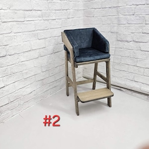 May include: A tall wooden chair with a dark blue upholstered seat and backrest, featuring a sturdy frame with a light brown finish and a built-in footrest. The chair has a high-back design with side supports and is labeled with the text #2.