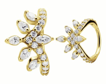May include: A pair of gold hoop earrings with a floral design. The earrings are adorned with clear cubic zirconia stones.