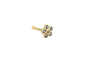 May include: A gold nose ring with a small flower design featuring blue gemstones.