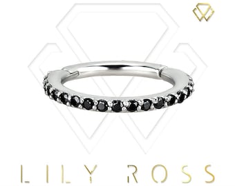 May include: A silver hinged segment ring with a row of black cubic zirconia stones.