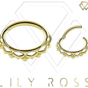 May include: Gold body jewelry with a decorative, scalloped edge. The jewelry is in the shape of a ring, and is shown from two different angles.